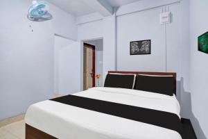 西隆Super Hotel O Lapalang Shillong的白色房间里有一张大床的卧室
