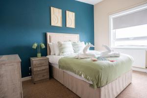 a bedroom with a bed with two stuffed animals on it at Marina House in Bathgate