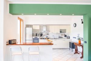 eine Küche mit weißen Geräten und einer grünen Decke in der Unterkunft Villa Lepre - Come to the silence in Casarza Ligure