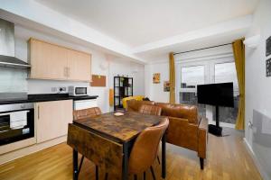 a kitchen and living room with a table and a couch at Vista View in Woolwich