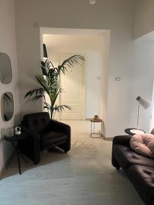 een woonkamer met een zwarte bank en een plant bij Deodato guesthouse in Catania