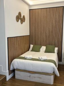 Un dormitorio con una cama grande con cabecero de madera. en Retiro Home, en Madrid