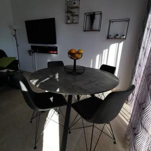 a dining room with a table with chairs and a television at Andromeda Hideaway in Polis Chrysochous
