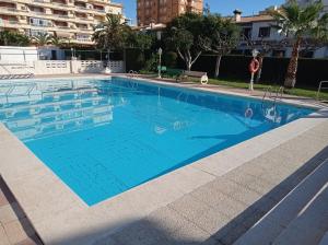 a large swimming pool with blue water at Los Iris Solo Familias Serviplaya in Playa de Gandia