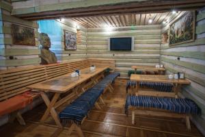 a dining room with wooden tables and benches and a statue at Shymbulak Resort Hotel in Almaty