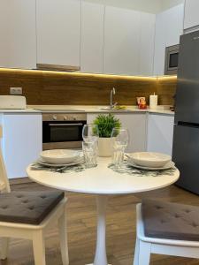 una mesa blanca con platos y vasos en ella en una cocina en Retiro Home, en Madrid 9 fotos más