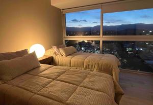 une chambre d'hôtel avec deux lits et une grande fenêtre dans l'établissement Departamento de lujo en el corazón de Mendoza, à Villa Marini 39 autres photos