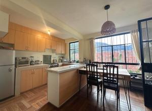 a kitchen with a table and some chairs in a room at Bright Riverside 3 Bedroom Stay Garden 5 min to Pisac in Taray