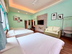 a bedroom with two beds and a tv and a couch at I WoW in Xiaoliuqiu