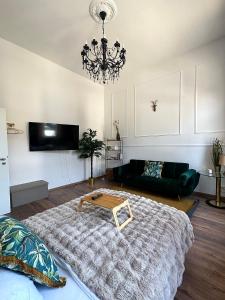 ein Wohnzimmer mit einem großen Bett und einem Kronleuchter in der Unterkunft Premium-Apartment im Duisburger Süden, nähe Düsseldorf Flughafen & Messe, Komplett ausgestattetes Apartment mit modernen Altbau-Flair in Duisburg