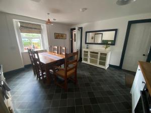 a dining room with a wooden table and chairs at The old Farmhouse Minutes from lochness in Drumnadrochit