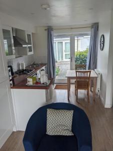 a kitchen and living room with a blue couch and a table at Saltbox B4 holiday cottage in Freshwater +1 photo