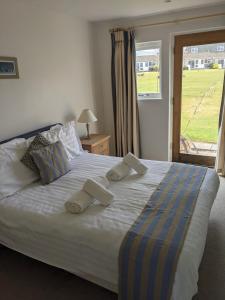 a bedroom with a bed with pillows and a window at Saltbox B4 holiday cottage in Freshwater