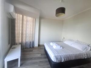 a bedroom with a bed and a table and a window at Apartamento Vai Vem in Madalena do Mar