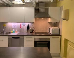a kitchen with white cabinets and a microwave at Svea Hostel in Stockholm