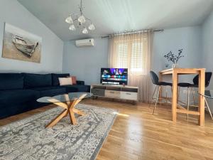 a living room with a blue couch and a table at Apartments Terra Solaris in Medulin
