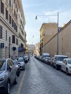 a street with cars parked on the side of a road at Cozy Colosseo in Rome