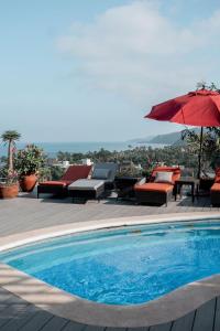 una piscina con sillas y sombrillas en un patio en Casa Salita, en Sayulita