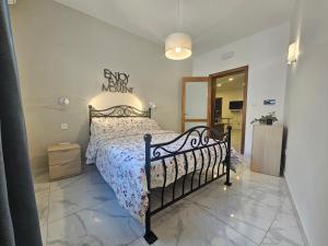 Un dormitorio con una cama con marco negro. en Pepprina, en St Paul's Bay