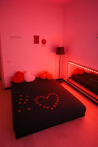 a bedroom with a black bed with red lighting at Lovers' Nest - Spa Apartment in Rome +17 photos