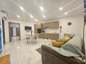 a living room with a couch and a kitchen at Pepprina in St. Paul's Bay