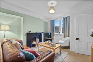 ein Wohnzimmer mit Couch und Kamin in der Unterkunft Daisy Cottage - North East Escapes in Corbridge