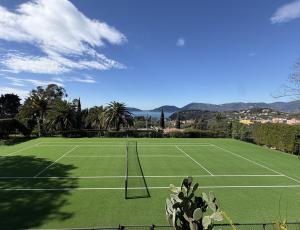 a tennis court with a net on a green field at "Quercia House", inside a Private Park, shared Pool, Tennis, AC, Parking next home and a Garage in Lerici! in Lerici
