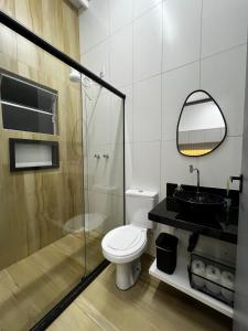 Un baño con inodoro, lavabo y ducha. en Loft Sulfurosa - 800m do Parque das Águas, en São Lourenço