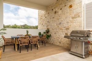 a patio with a table and chairs and a grill at Fantasea Villas, villa Lumi in Stérnai
