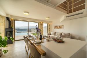 a dining room and living room with a table and chairs at Fantasea Villas, villa Lumi in Stérnai