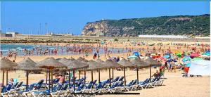 un grupo de personas en una playa con sillas y sombrillas en Ático en Barbate, en Barbate