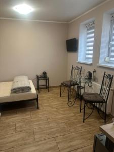a room with chairs and a table and a bed at Willa Leszczynko - pokoje gościnne in Leszno