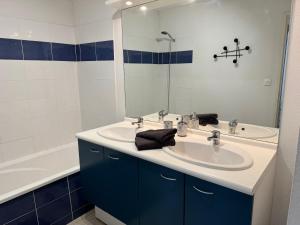 a bathroom with a sink and a mirror and a tub at Appartement tout confort avec parking privé in Montréjeau
