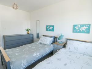 a bedroom with two twin beds and a dresser at 6 Gwel Yr Wyddfa in Rhosneigr