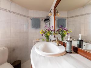 a bathroom with a sink and a mirror and flowers at Alexandra House in Kríni +20 photos
