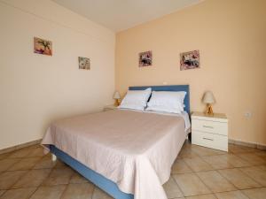 a bedroom with a bed and a nightstand and pictures on the wall at Alexandra House in Kríni