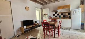a kitchen with a table and chairs and a refrigerator at Maison de Ville in Saint-Christophe-du-Ligneron