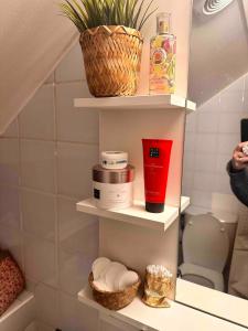 un bagno con scaffali e alcuni oggetti. di Magical studio, good vibes a Enghien-les-Bains