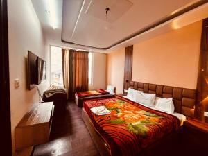 NainitalPatang Guest House的有两张床和一台电视的酒店房间 更多8张照片