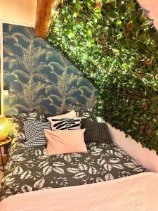 un letto con cuscini e piante appesi a un muro di Magical studio, good vibes a Enghien-les-Bains