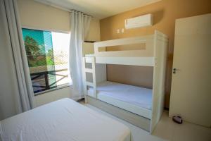 a bedroom with two bunk beds and a window at Apto com lazer completo, Wi-Fi e bem equipado in Praia do Saco +33 photos