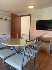 a dining room with a table and chairs and a flat screen tv at Deep Blue Sea view apartments Vodice in Vodice