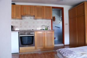 a kitchen with wooden cabinets and a sink and a stove at Deep Blue Sea view apartments Vodice in Vodice +7 photos