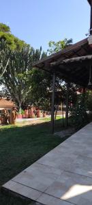 a wooden pergola in a park with plants in the background at Refugio Namastê - Sheila in São Pedro da Aldeia
