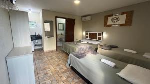a hotel room with two beds and a bathroom at Sonhos de Penha - Chalés e Aptos in Penha