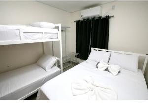a bedroom with two bunk beds with a bow at Hotel Paraiso Go in Valparaíso de Goiás