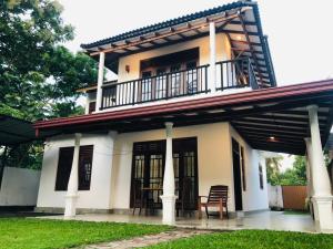 una casa con un balcone in cima di 360 Lotus Hostel Tangalle and Cowork a Tangalle