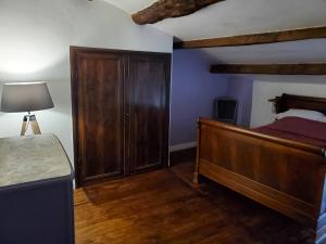 a bedroom with a bed and a wooden cabinet at La cardabelle in Saint-Maurice-Navacelles +21 photos