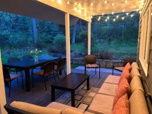 a patio with a table and chairs and a couch at Whitefish Home, Sleeps 7, Hot Tub, AC in Whitefish