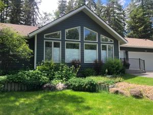 a house with large windows in a yard at Whitefish Home, Sleeps 7, Hot Tub, AC in Whitefish